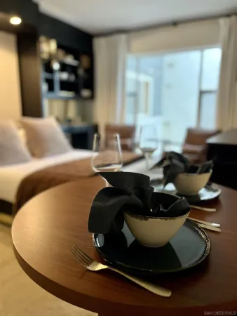 a living room with a table chair and a floor to ceiling window