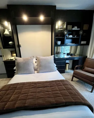 a bedroom with a bed window and dresser