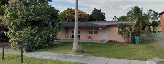 a view of a backyard with a barn and a large tree