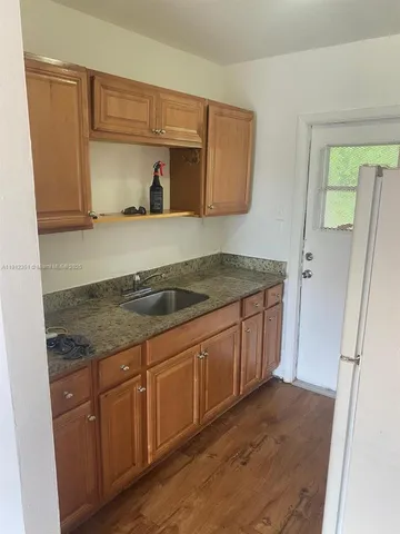 a kitchen with granite countertop a sink and cabinets