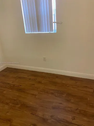 a view of a room with an empty space and a window