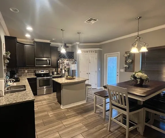 a view of a dining room and livingroom with furniture wooden floor a chandelier