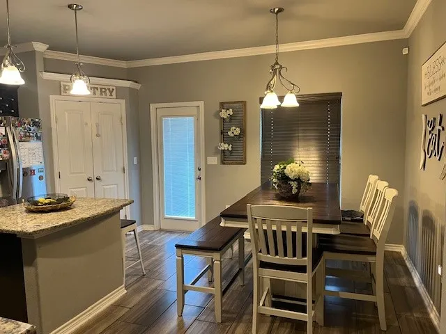 a kitchen with stainless steel appliances kitchen island granite countertop a stove a sink dishwasher and a refrigerator with wooden floor