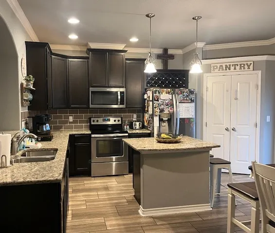 a kitchen with a refrigerator a stove top oven a sink and dishwasher