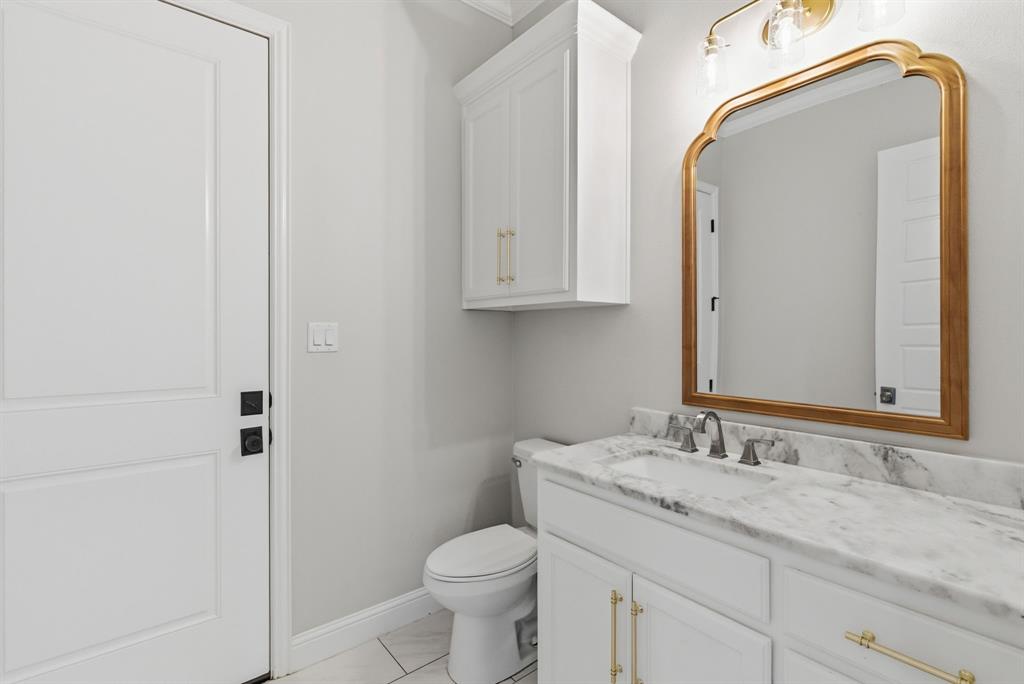 4600 Old Brock Road Weatherford, TX 76087 - Photo 20 of 37 Bathroom featuring a vanity with a white stone countertop, undermount sink, and a gold-framed mirror