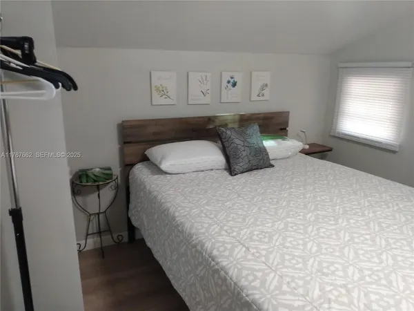 a large bed sitting in a bedroom next to a window