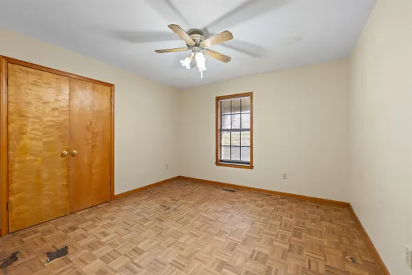 an empty room with a window and a fan