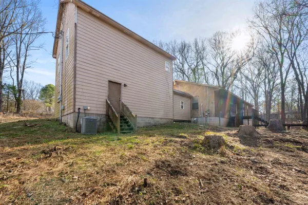 a view of a house with backyard and trees