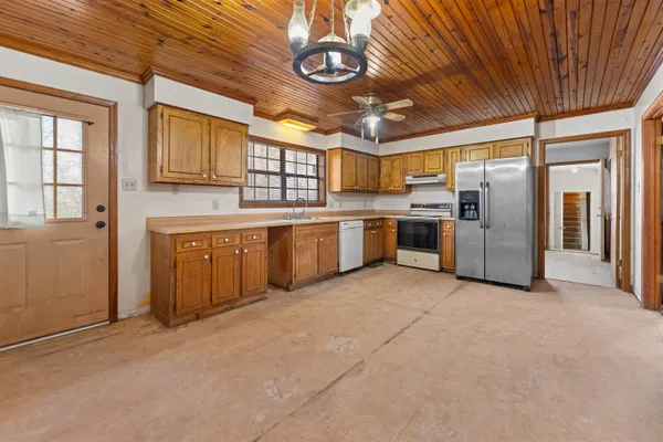 a large kitchen with stainless steel appliances granite countertop a stove refrigerator and cabinets
