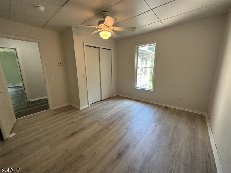 213 Sand Shore Road Budd Lake, NJ 07828 - Photo 12 of 26 an empty room with wooden floor and windows