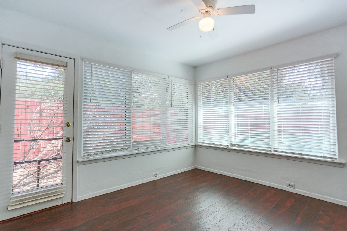 1003 Beaver Trail, Unit A Austin, TX 78746 - Photo 9 of 15 a view of an empty room with wooden floor and a window