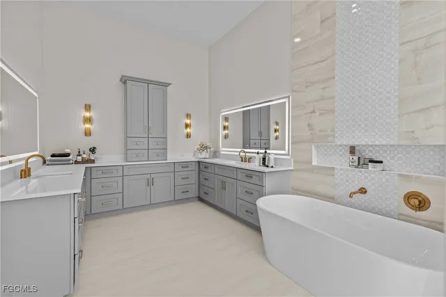 a bathroom with a tub a sink double vanity and mirror