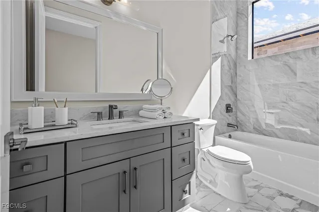 a bathroom with a granite countertop sink a toilet and a bathtub