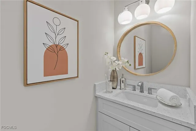 a bathroom with a granite countertop double vanity sink and a mirror