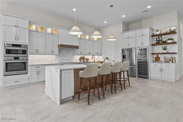 a large kitchen with cabinets chairs and stainless steel appliances