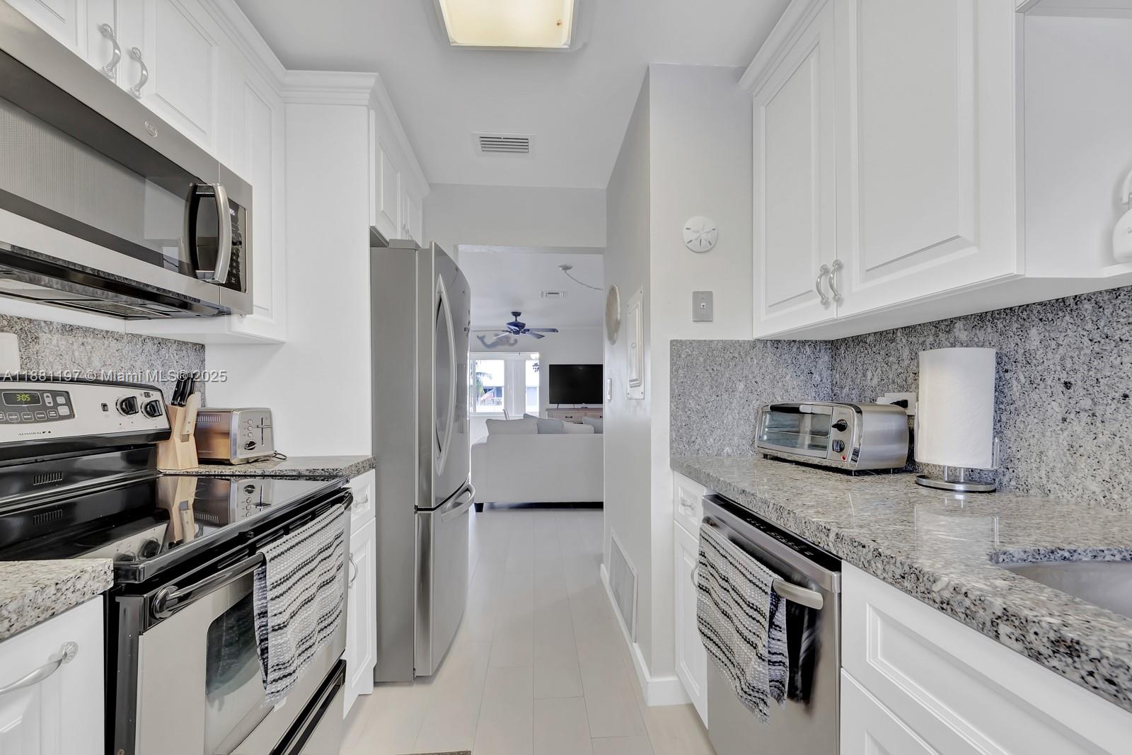 308 Sombrero Beach Road Marathon, FL 33050 - Photo 11 of 43 a kitchen with stainless steel appliances granite countertop a sink stove and refrigerator