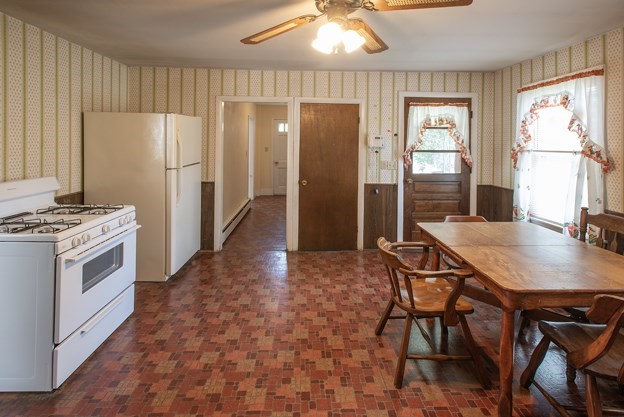 40 Ryan Road Northampton, MA 01062 - Photo 9 of 19 a kitchen with stainless steel appliances a refrigerator a stove a dining table and chairs with wooden floor