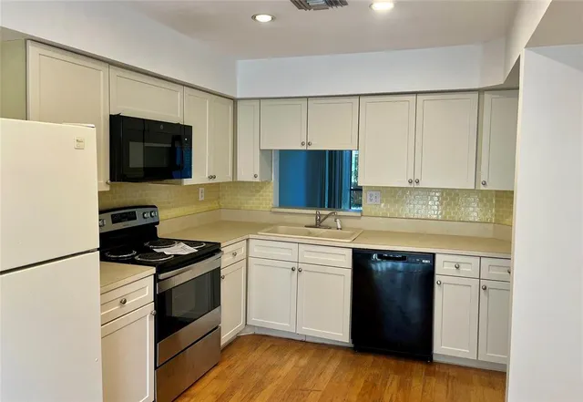 a kitchen with stainless steel appliances a stove sink and microwave