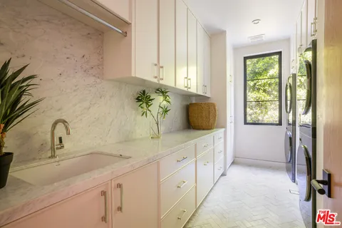 a bathroom with a sink and mirror with window