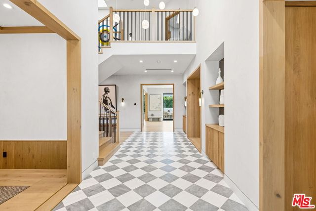 a view of a hallway with wooden floor and windows