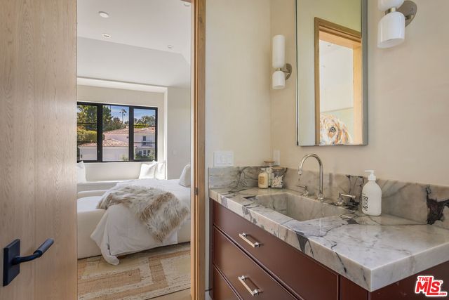 a en suite bathroom with a granite countertop sink and a window