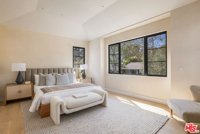 a bedroom with a bed and a large window