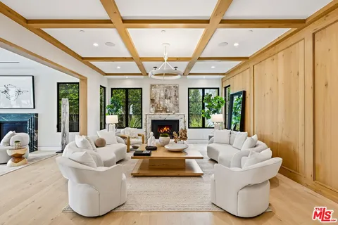 a living room with fireplace furniture and a large window