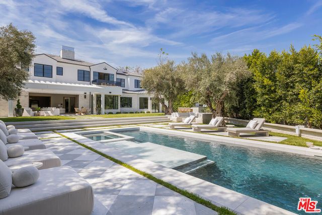 a view of a house with swimming pool and sitting area