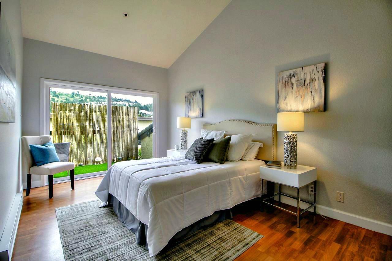 207 Monterey Road, Unit 7 Pacifica, CA 94044 - Photo 13 of 34 a bedroom with a bed and a lamp next to a window