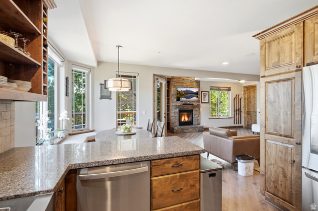 3148 Lower Saddleback Road Park City, UT 84098 - Photo 8 of 67 Kitchen featuring granite countertops, wood-finish flooring, custom wood cabinetry, stainless steel dishwasher, and a stone-clad fireplace