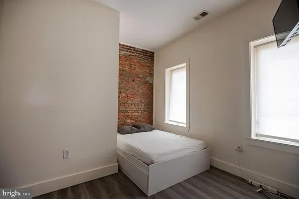 a white bed sitting in a bedroom next to a window