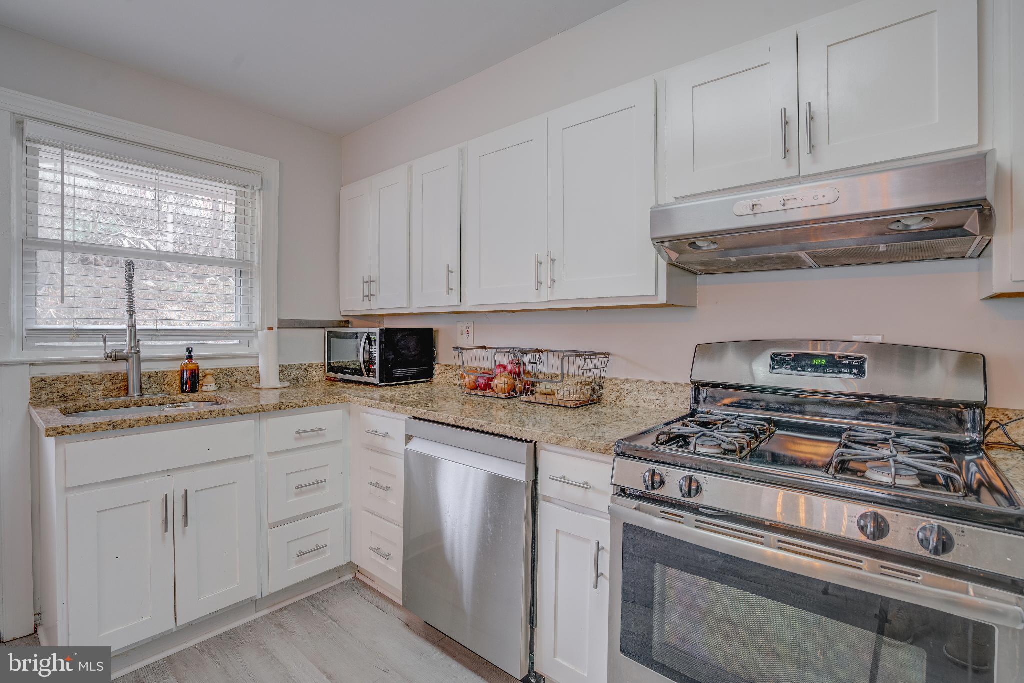 4814 Briarclift Road Baltimore, MD 21229 - Photo 11 of 34 a kitchen with white cabinets and appliances