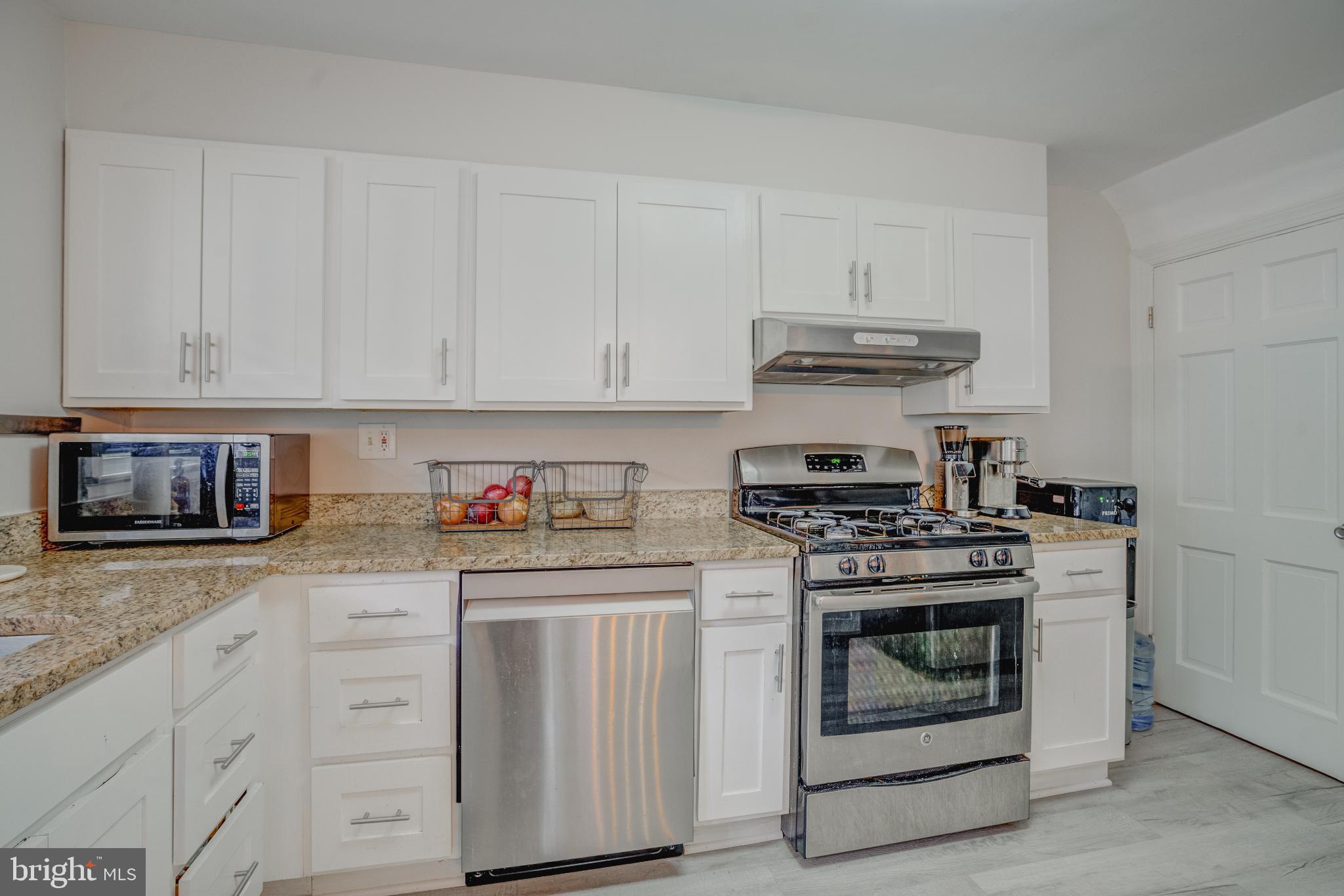 4814 Briarclift Road Baltimore, MD 21229 - Photo 12 of 34 a kitchen with stainless steel appliances granite countertop a stove and white cabinets