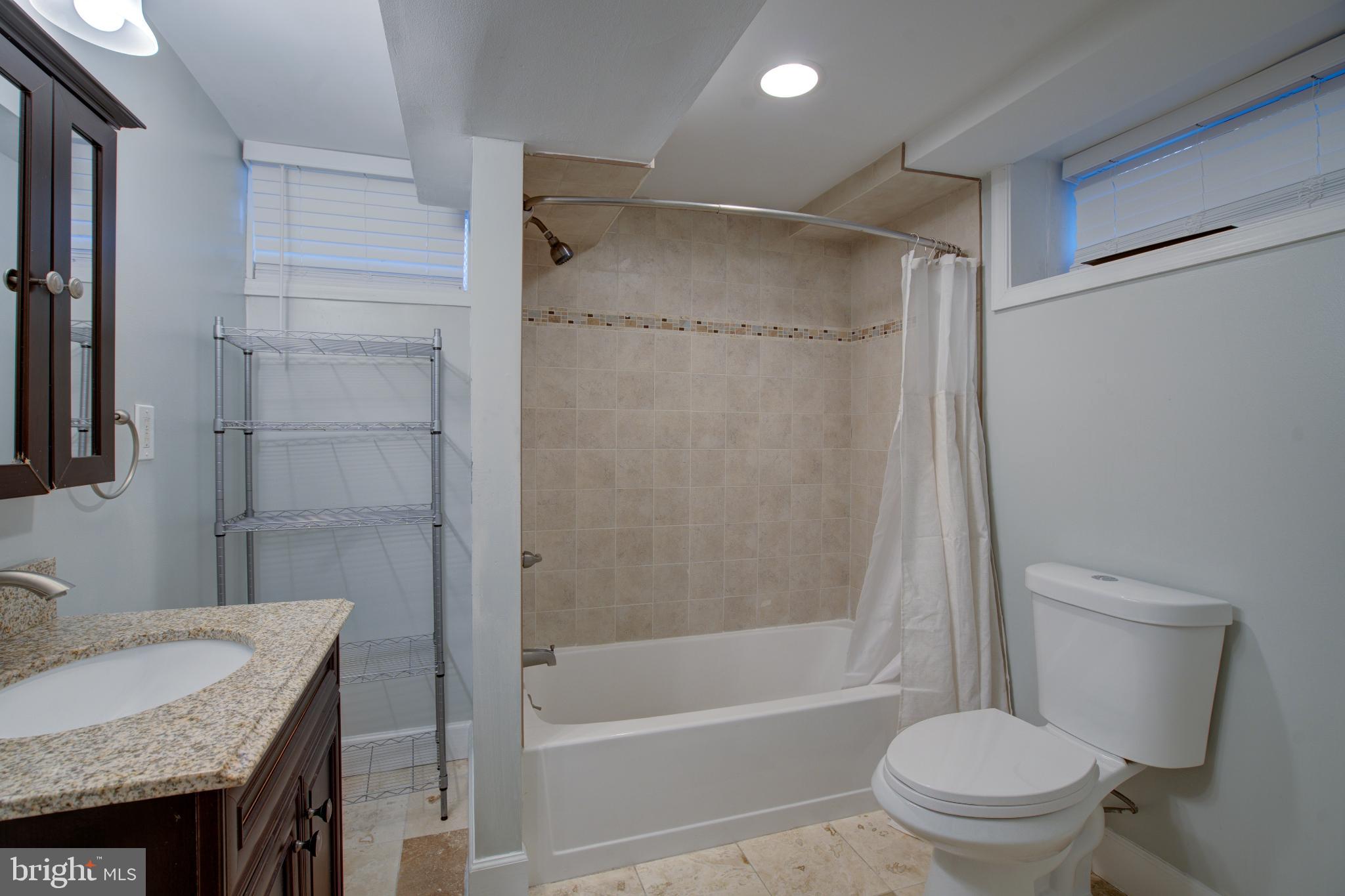 4814 Briarclift Road Baltimore, MD 21229 - Photo 26 of 34 a bathroom with a granite countertop bathtub shower sink vanity and toilet