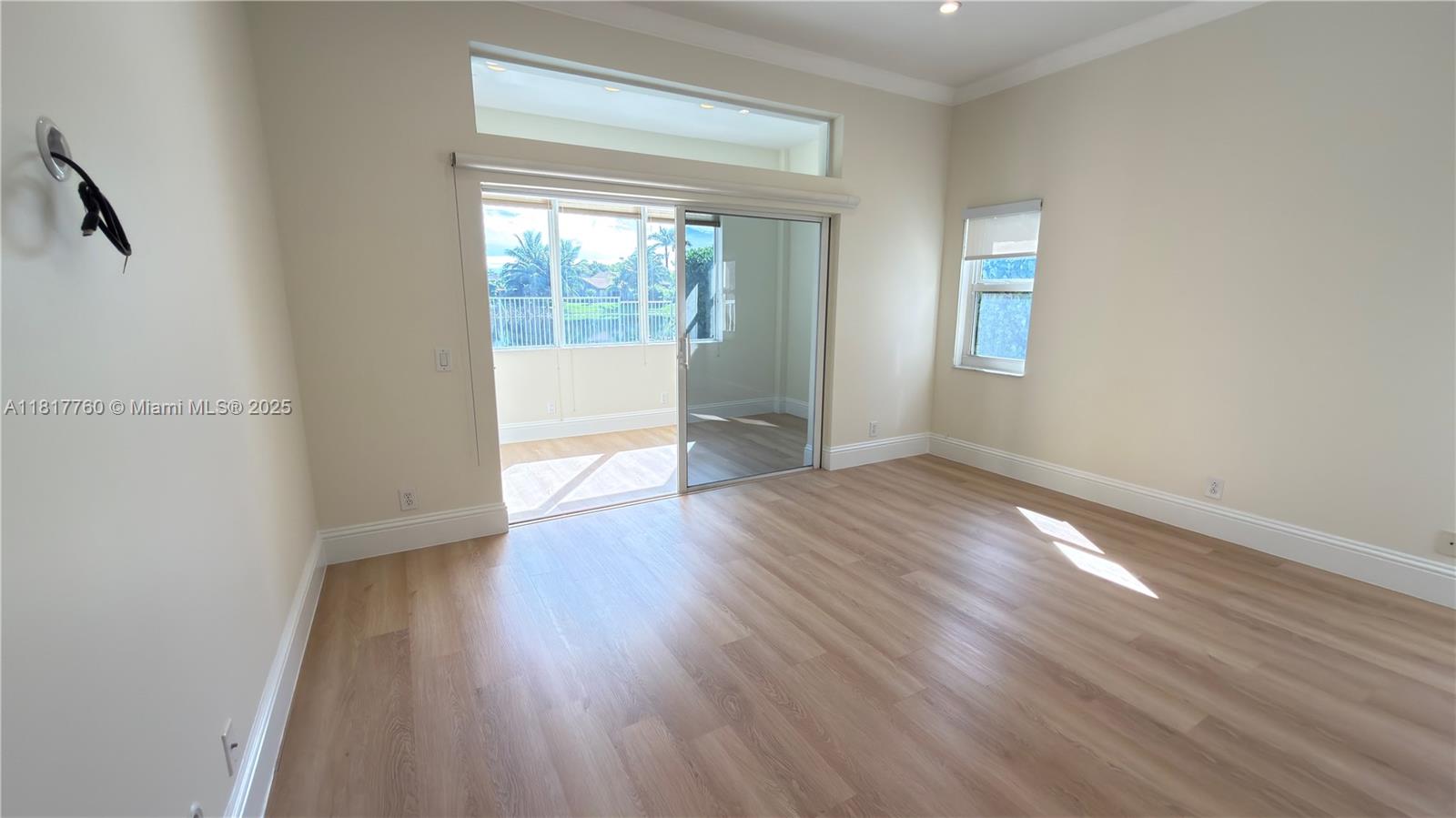 4221 Laurel Ridge Circle Weston, FL 33331 - Photo 16 of 57 a view of an empty room with wooden floor and a window