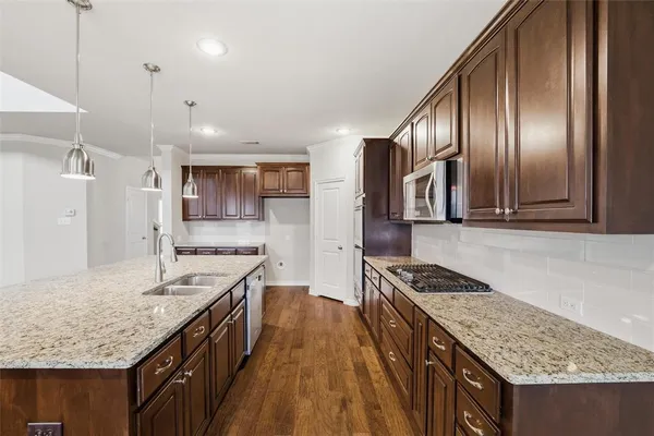 a kitchen with stainless steel appliances granite countertop a kitchen island a stove and a sink