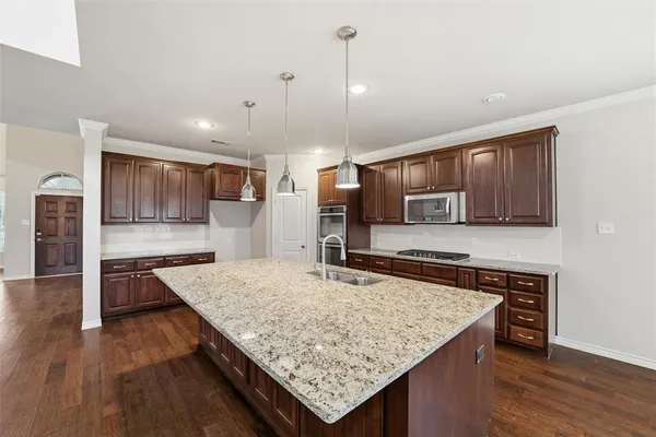 a kitchen with stainless steel appliances granite countertop wooden cabinets and stove