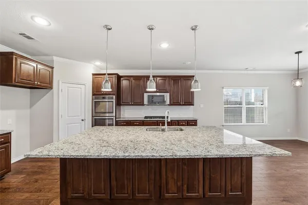 a kitchen with kitchen island a sink and wooden floor