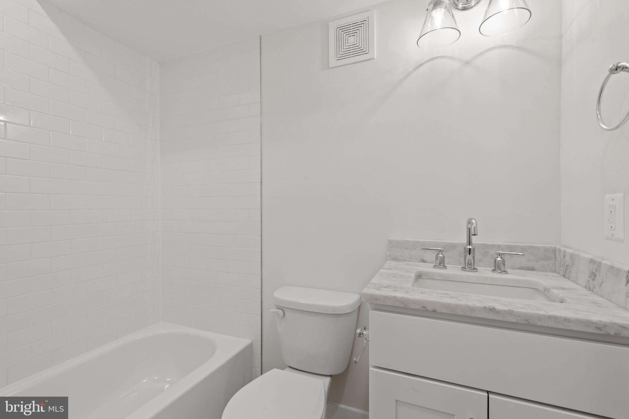 1005 Riverside Avenue Baltimore, MD 21230 - Photo 29 of 29 a bathroom with a granite countertop sink toilet and shower