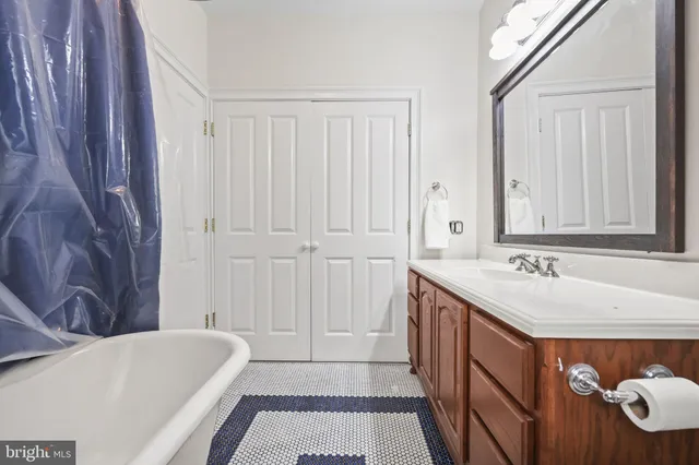 a bathroom with a tub sink and mirror