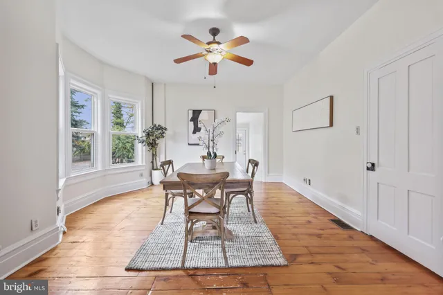 a dining room with wooden floor and a rug