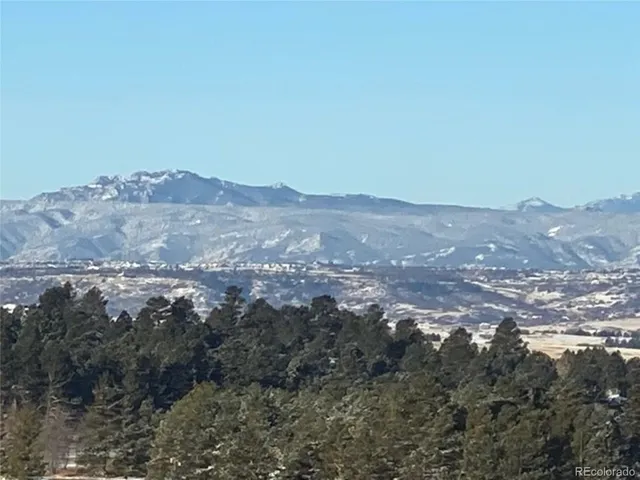 a view of a big yard with mountains in the background