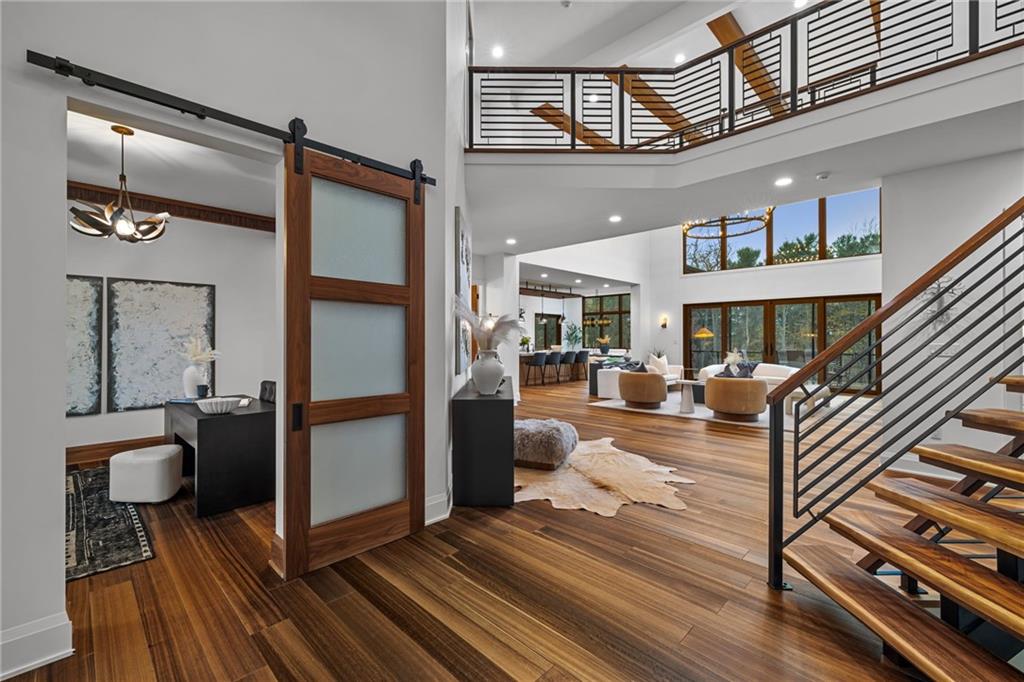 10485 Grubbs Road Wexford, PA 15090 - Photo 20 of 50 View of the home's two story entry and into the two story great room. The live edge steps also feature custom metal fabricated railings. To the left, a modern barn door featuring rain glass, opens to the main level study