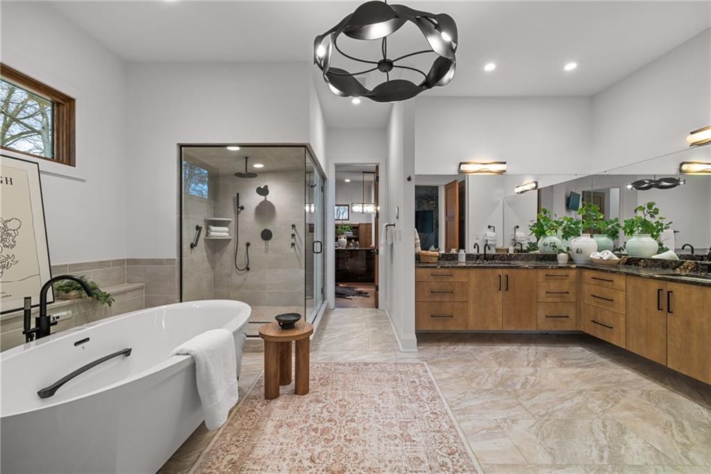 10485 Grubbs Road Wexford, PA 15090 - Photo 25 of 50 Heated floors in the primary bath. Stylish Hubbardton Forge chandelier. Steam shower with custom glass surround and Bain Ultra freestanding air tub. Armina Stone Orion leathered countertops and Rutt Cabinetry.