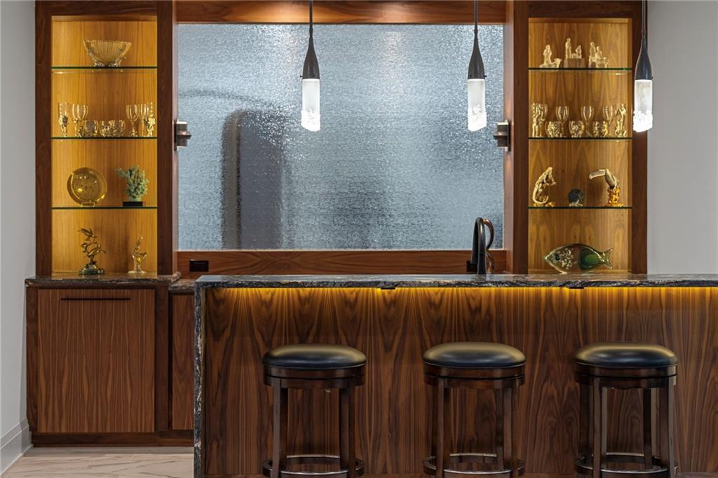 10485 Grubbs Road Wexford, PA 15090 - Photo 42 of 50 The custom bar features Stone Orion Leathered countertops with water edge and LED accent lighting and Hubbardton Forge Fritz pendants.