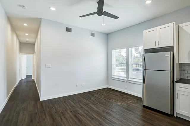 a view of empty room with wooden floor and window