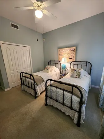 a spacious bedroom with two beds and a chandelier