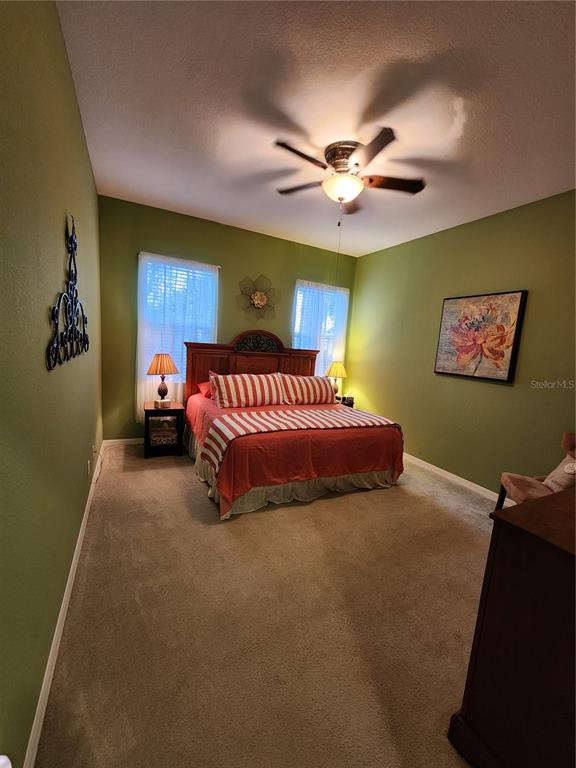 400 Ravinia Circle, Unit 400 Venice, FL 34292 - Photo 19 of 31 a spacious bedroom with a bed and a ceiling fan