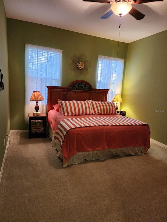 400 Ravinia Circle, Unit 400 Venice, FL 34292 - Photo 20 of 31 a spacious bedroom with a bed and a chandelier