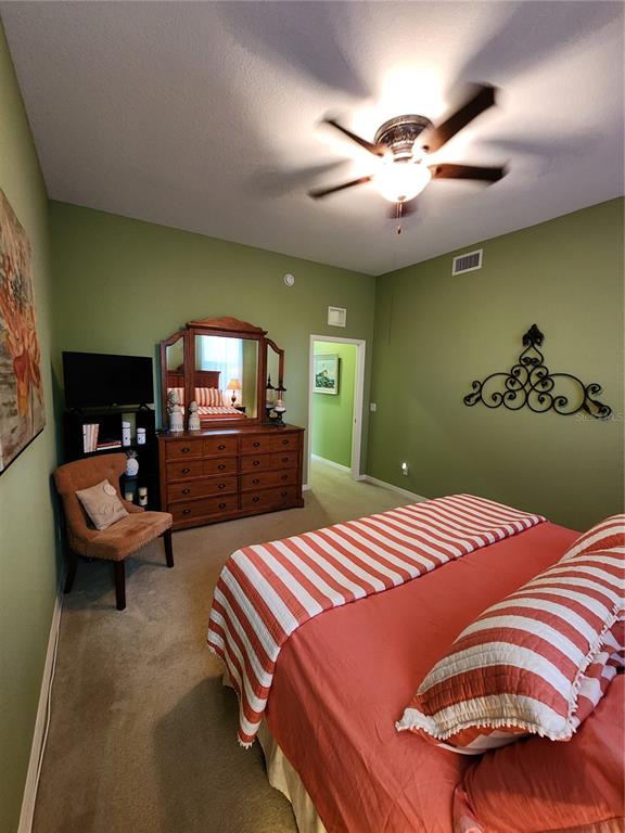 400 Ravinia Circle, Unit 400 Venice, FL 34292 - Photo 22 of 31 a bedroom with a bed and a chandelier